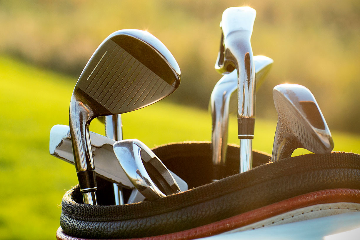 Golf clubs in a golf bag in the sun