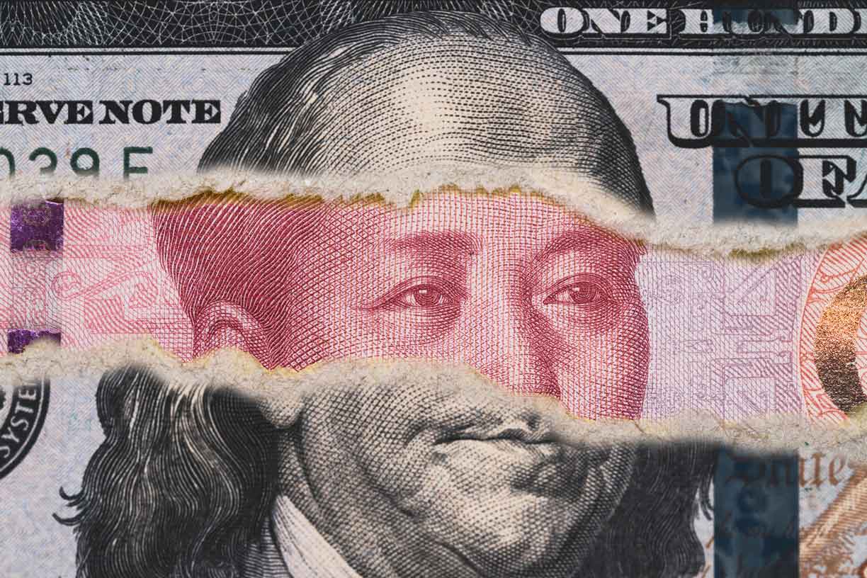 Benjamin Franklin on USD dollar banknote tear with Mao Tse Tung on Yuan banknote