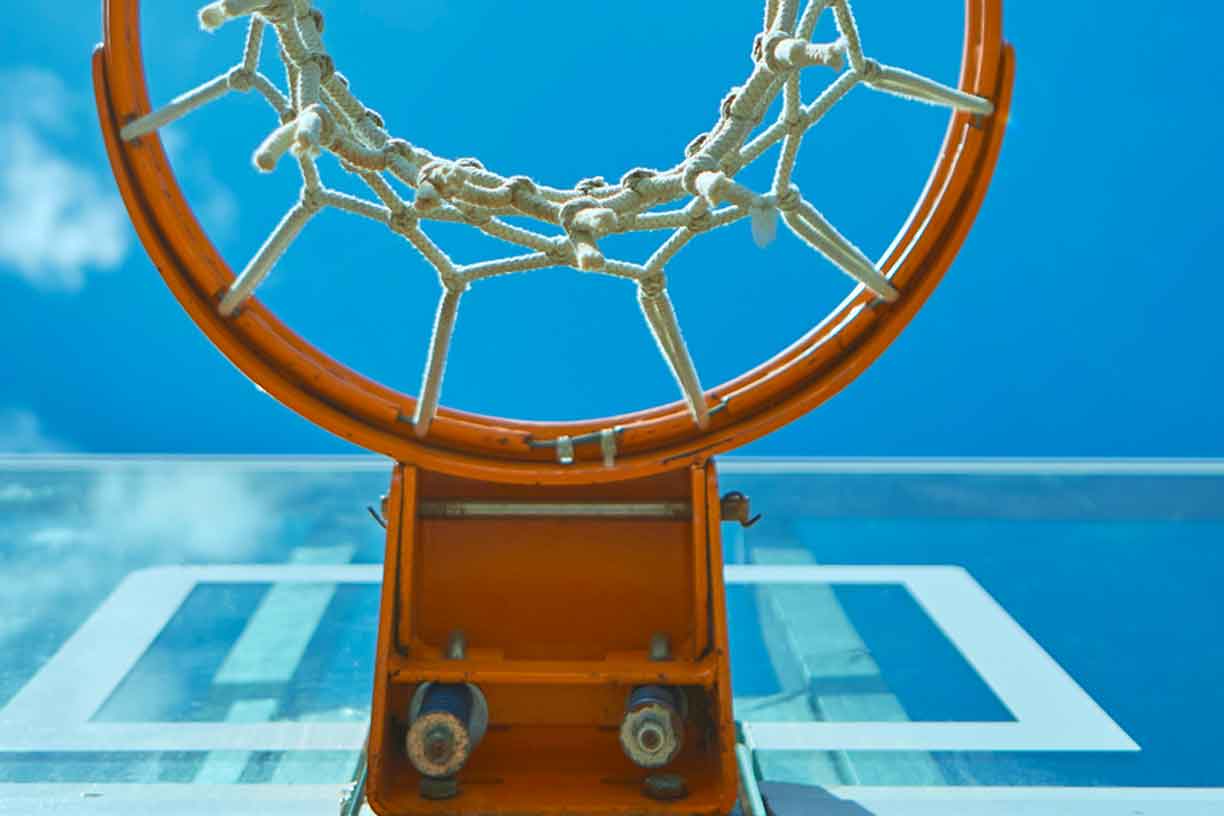 view of basketball net from underneath with sky in background